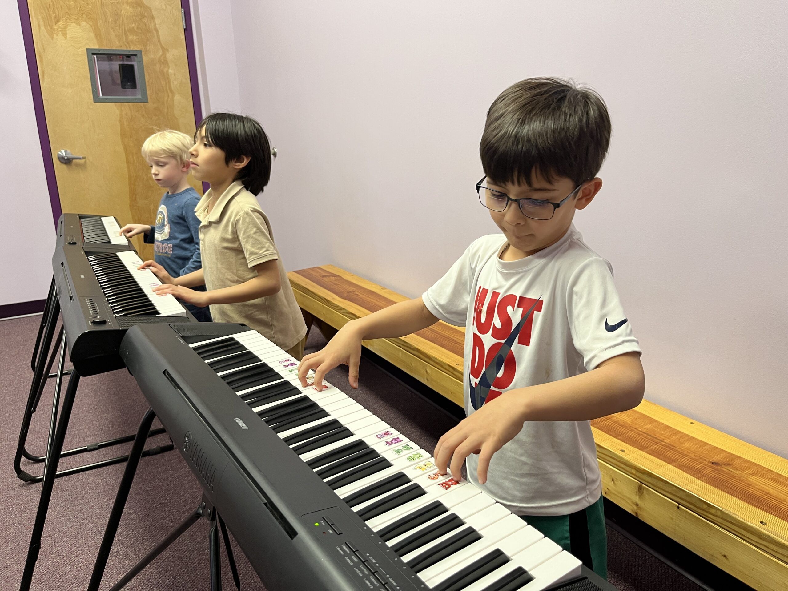 kids playing piano in a group class